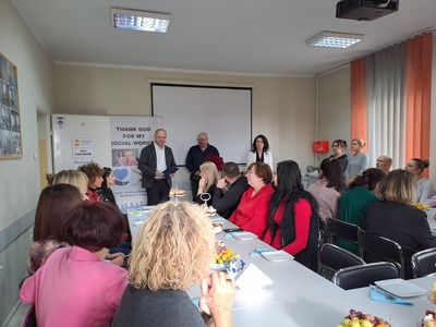 1)	Zdjęcie wykonane w sali wykładowej M-GOPS w Sompolnie. Przedstawia Pana Waldemara Marciniaka - burmistrza miasta Sompolna wraz z Panią Anetą Niestrawską - kierownik administracyjną urzędu składających życzenia Panu Tomaszowi Majewskiemu - dyrektorowi oraz pracownikom mgops w Sompolnie.