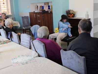 Na zdjęciu widać dziewczynkę w czapce występującą przed widownią  na sali głownej DDP