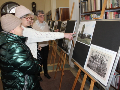 Na fotografii seniorki oglądające zdjęcia dawnego dworca kolejowego w Sompolnie.