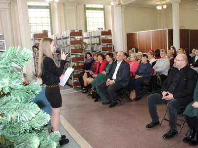 1. Zdjęcie wykonane w MGBP w Sompolnie. Przedstawia występ uczennicy oraz widownie siedzącą na krzesełkach