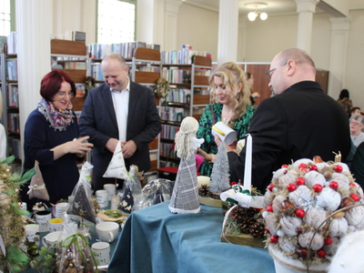 4. Zdjęcie przedstawia zebranych gości w MGBP w Sompolnie, podczas oglądania wystawy prac plastycznych