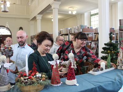 5. Na zdjęciu widać grupę osób oglądających rękodzieło.