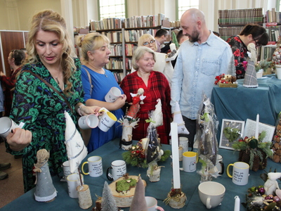 6. Zdjęcie przedstawia grupę osób zainteresowanych wystawą rękodzieła