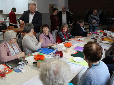 2)	Na zdjęciu seniorzy, goście oraz pan burmistrz rozdający czekoladowe mikołaje.