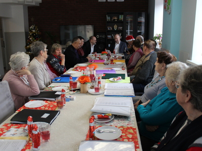 4)	Na fotografii wszyscy uczestnicy spotkania siedzący przy jednym stole.