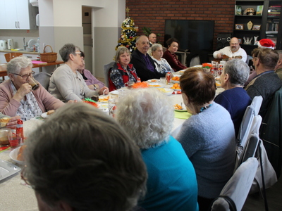5)	Na zdjęciu uczestnicy spotkania grają i śpiewają kolędy.