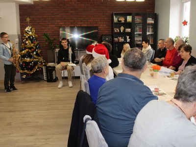 5. Zdjęcie przedstawia występ ucznia, który gra na saksofonie przed widownią złożoną z seniorów z DDP