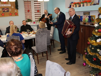 4)	Zdjęcie przedstawia kolędujących uczestników spotkania wigilijnego