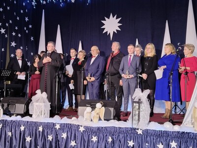3)	Zdjęcie przedstawia uczestników samorządowego kolędowania stojących na scenie.