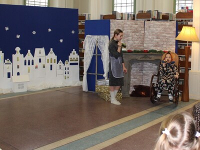 3)	Zdjęcie przedstawia dziewczynę przebraną za babcię, siedzącą w bujanym fotelu oraz młodą aktorkę grającą dziewczynkę z zapałkami.