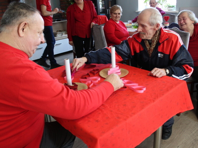Zdjęcie przedstawia dwóch seniorów grających w grę zręcznościową.