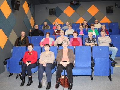 Zdjęcie wykonane w Kinie za rogiem w Sompolnie. Przedstawia grupę seniorów z DDP przygotowującą się do oglądania filmu.