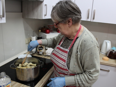 3) Zdjęcie przedstawia jedną z uczestniczek która smaży faworki.