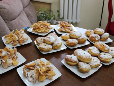 4) Na fotografii stół na którym stoją talerze z pączkami i chruścikami.