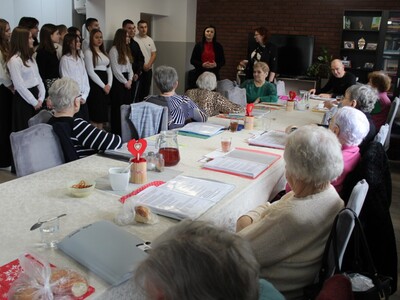 1 .Zdjęcie wykonane na sali głó9wnej DDP. Przedstawia młodzież oraz nauczycielki , którzy przybyli w odwiedziny do Seniorów