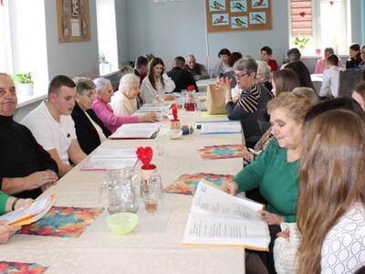 5. Zdjęcie przedstawia wszystkich zgromadzonych biesiadujących razem przy wspólnym stole.