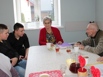 6. Zdjęcie przedstawia dyskutujących z seniorami chłopców.