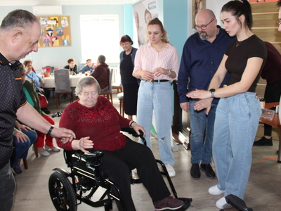 Na zdjęciu jedna z uczestniczek ddp siedząca na wózku elektrycznym. Wokół seniorzy z ddp oraz pracownicy mgops w sompolnie.