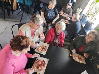 Na zdjęciu seniorzy degustują wykonaną przez siebie pizze.