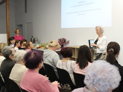 5. Zdjęcie wykonane na tle projektora w czasie trwania warsztatów edukacyjnych podczas których jedna z Pań omawia kwestie związane z profilaktyką przeciwnowotworową.