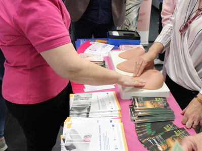 7. Na zdjęciu przedstawione są materiały edukacyjne w tematyce raka piersi i jąder, oraz praktyczna część spotkania – nauka wykonywania samobadania piersi przez kobiety obecne na spotkaniu.