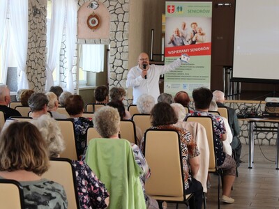 Zdjęcie wykonane w sali OSP Sompolno. Przedstawia  dyrektora miejsko – Gminnego Ośrodka Pomocy Społecznej w Sompolnie prezentującego Kopertę życia
