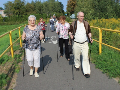 Zdjęcie przedstawia seniorów podczas spaceru nordic walking 