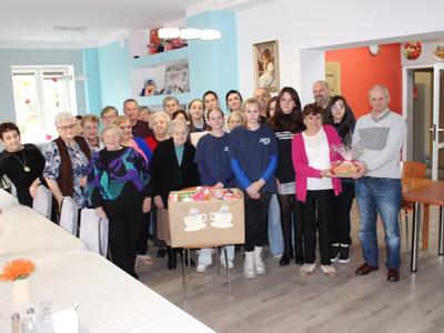 Zdjęcie grupowe wykonane w sali głównej ddp. Prezentuje wszystkich uczestników spotkania: dzieci, seniorów i opiekunów.