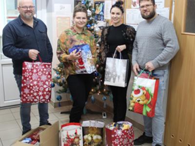 Zdjęcie wykonane w Miejsko - Gminnym Ośrodku Pomocy Społeczne w Sompolnie. Przedstawia od lewej: Pana Tomasza Majewskiego - Dyrektora MGOPS w Sompolnie, Panią Angelikę Grzegorską - pracownicę MGOPS, Panią Alicję Wochna - nauczycielkę ZSP w Mąkolnie oraz Pana Łukasza Suliburskiego - pracownika MGOPS w Sompolnie z paczkami słodyczy ofiarowanymi przez szkołę w Mąkolnie.