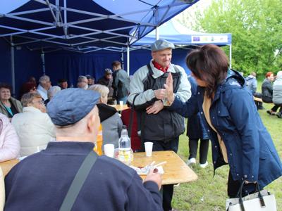 13) Na zdjęciu widzimy Panią Anetę Niestrawską – Sekretarz Gminy Sompolno, która rozmawia z seniorami na Majówce.