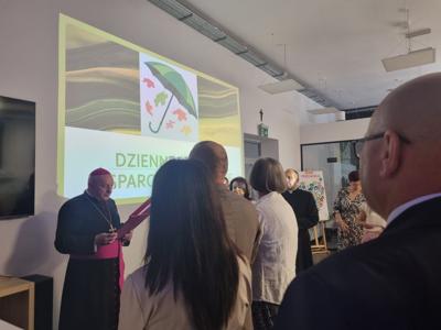 Na fotografii burmistrz i osoby uczestniczące w spotkaniu na tle logo DCW.