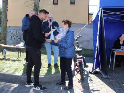 Na fotografii dyplom i upominek otrzymuje najstarsza uczestniczka marszu