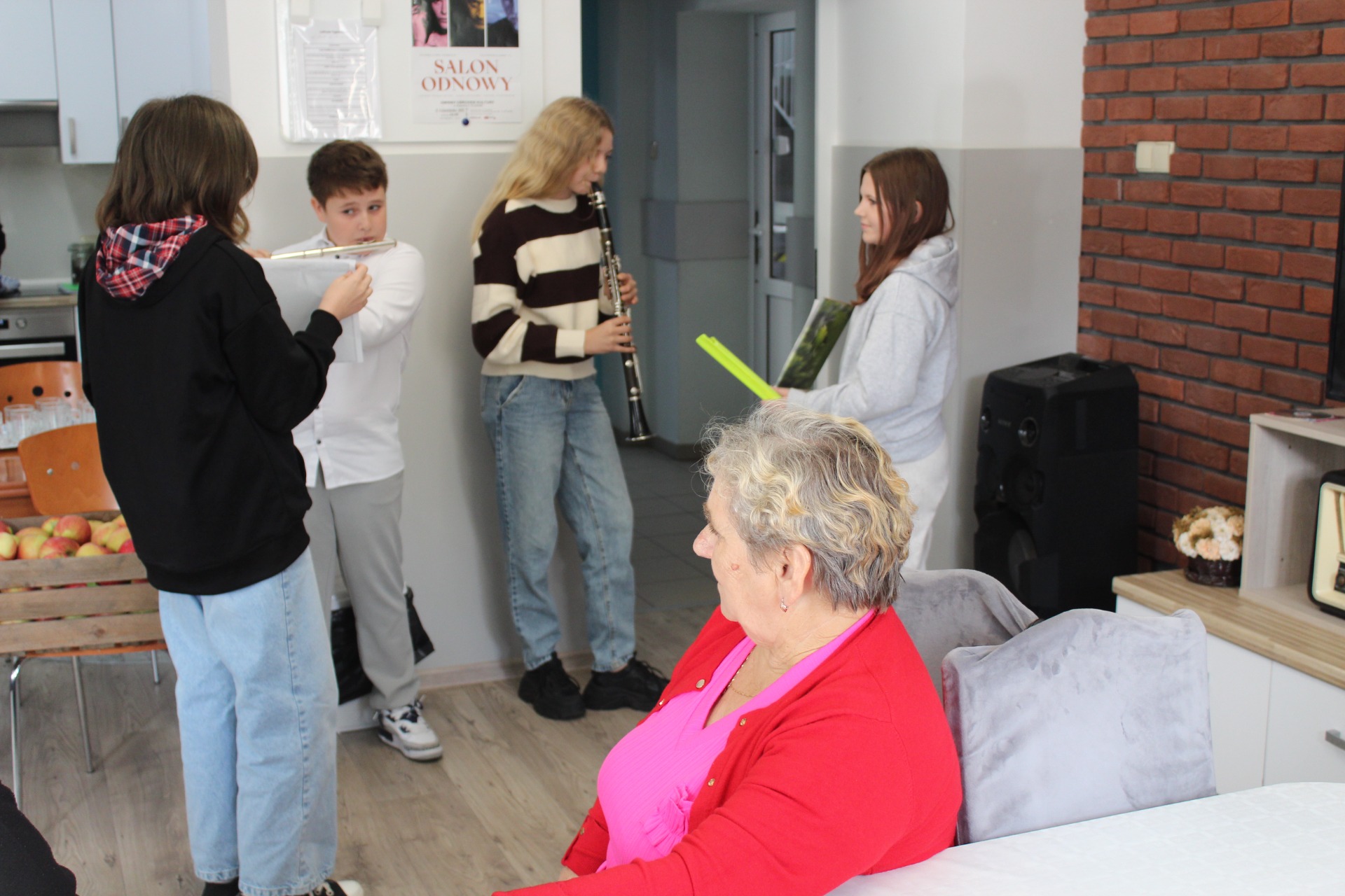 Zdjęcie wykonane w domu sali głównej Domu Dziennego Pobytu – przedstawia dzieci grające na instrumentach