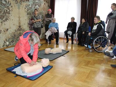 4) Zdjęcie przedstawia uczestniczkę spotkania, która ćwiczy na fantomie umiejętność wykonania resuscytacji krążeniowo-oddechowej