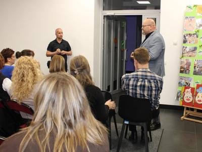 5) Zdjęcie przedstawia dyrektora mgops, Pawła Boguszewskiego oraz osoby zebrane podczas wykładu.