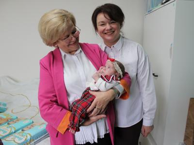 5) Zdjęcie przedstawia przedstawicielki urzędu. Jedna z nich trzyma na rękach dziecko.