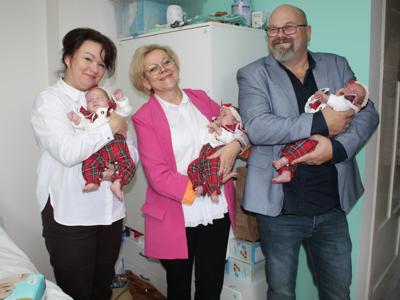 6) Zdjęcie przedstawia przedstawicieli urzędu trzymających na rękach trojaczki.