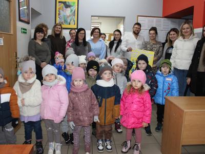 Zdjęcie grupowe przedstawia pracowników socjalnych wraz z przedszkolakami.